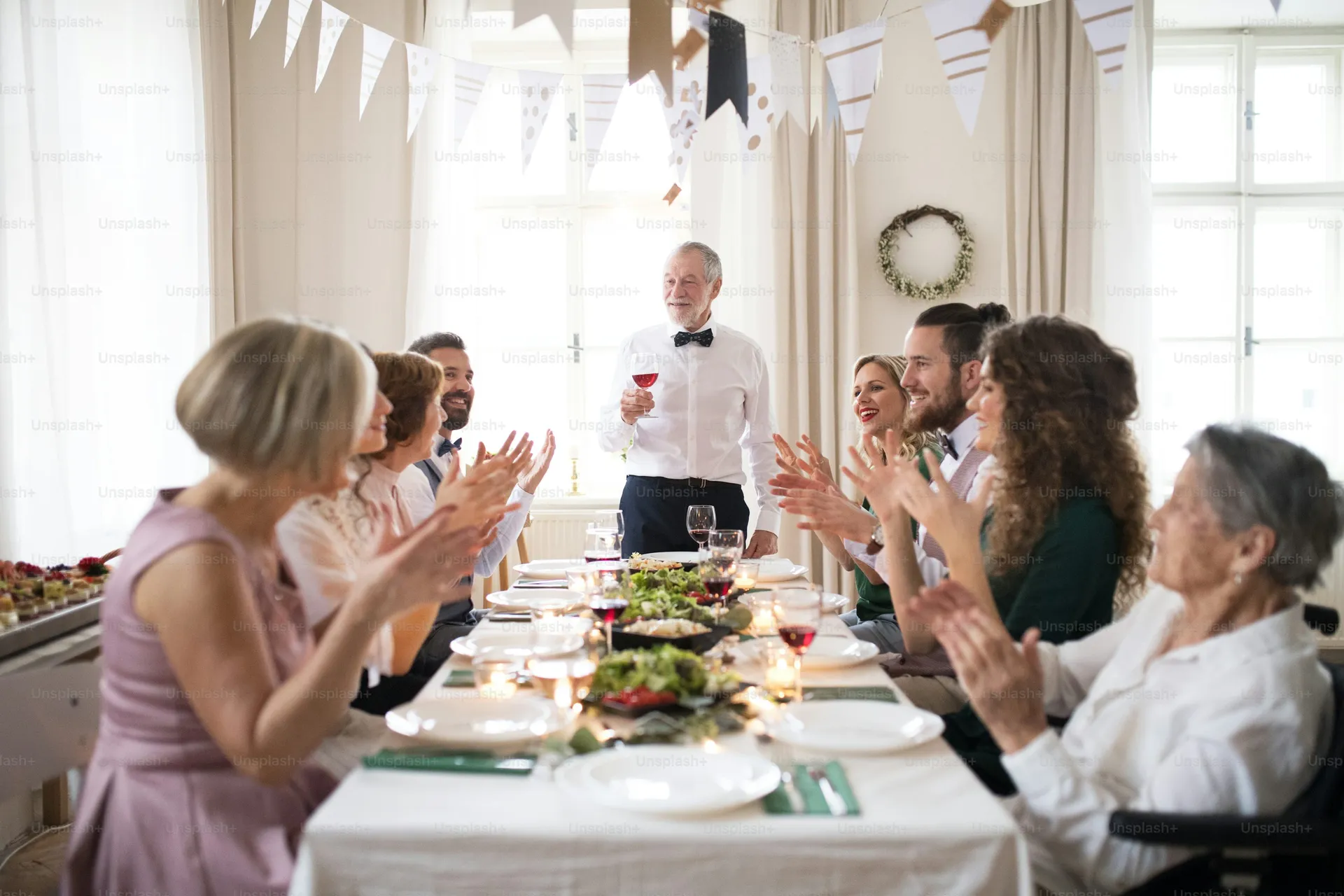 Multi-generational family gathered around a table celebrating a 60th birthday