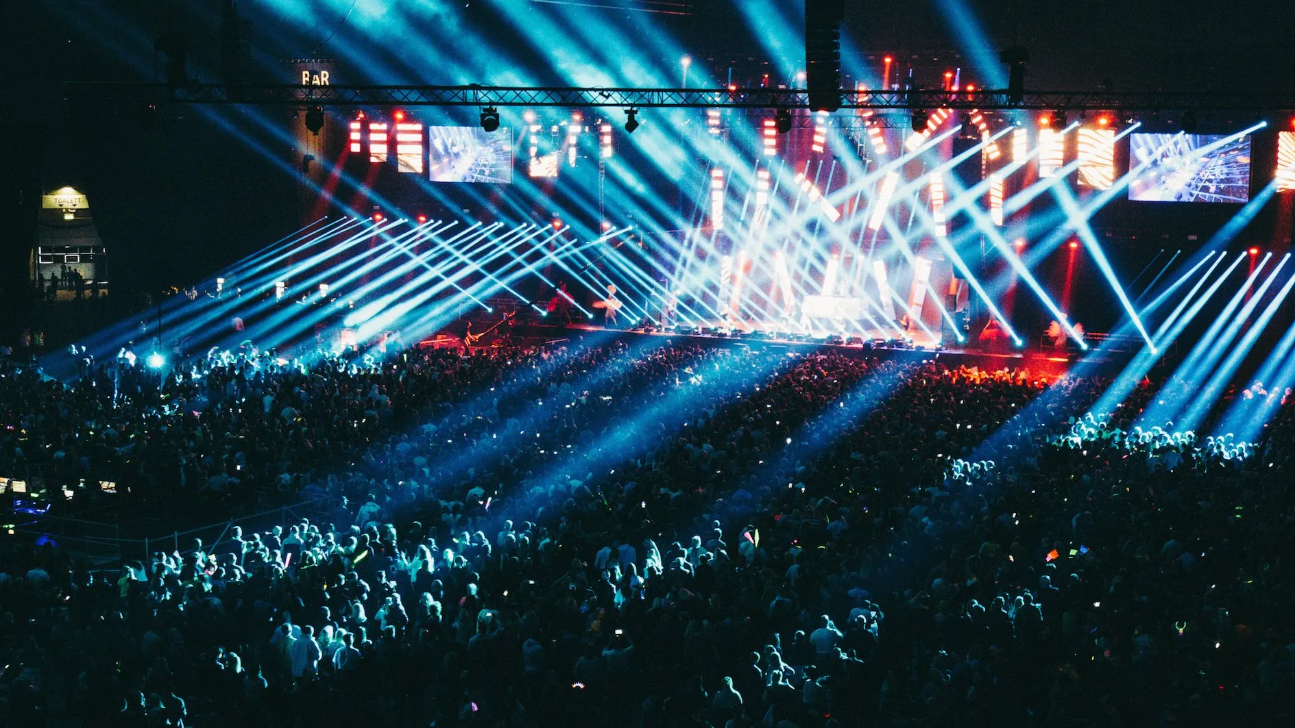 Large concert stage with dramatic lighting and a crowd at night