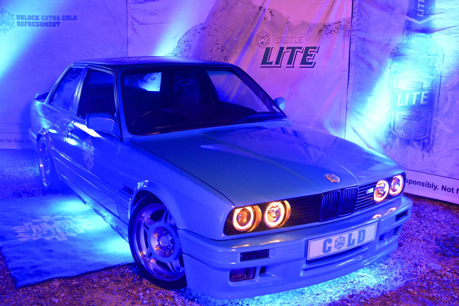Castle Lite branded BMW display car under blue lighting at a B&W Productions activation
