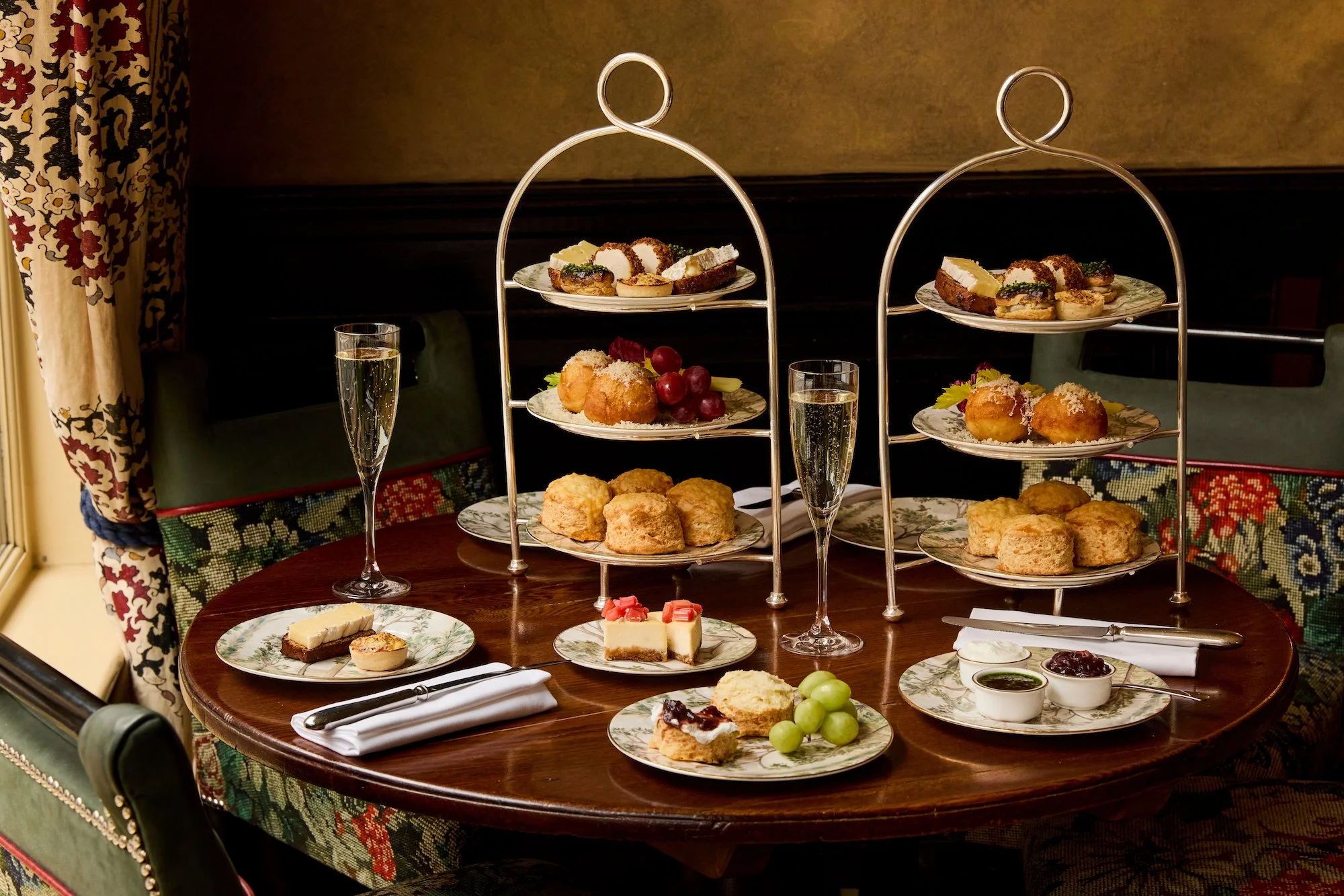 A tiered afternoon-tea stand with scones, macarons and finger sandwiches