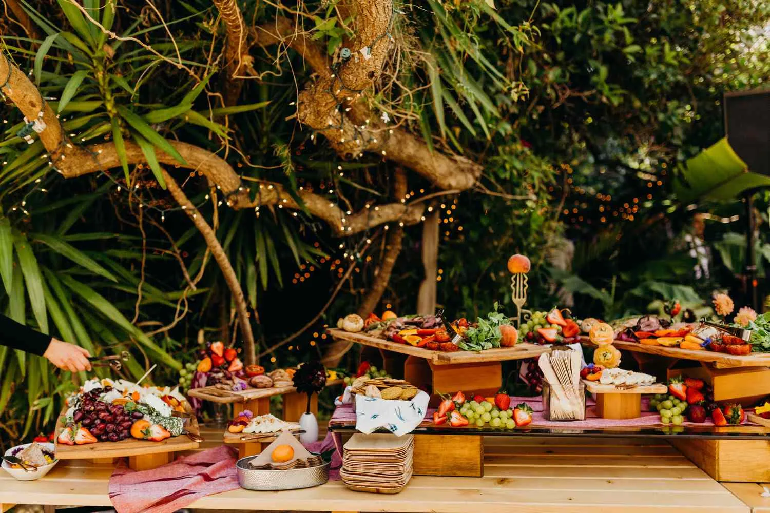 A modern grazing table laden with cheeses, fruit and flowers at a chic kitchen tea