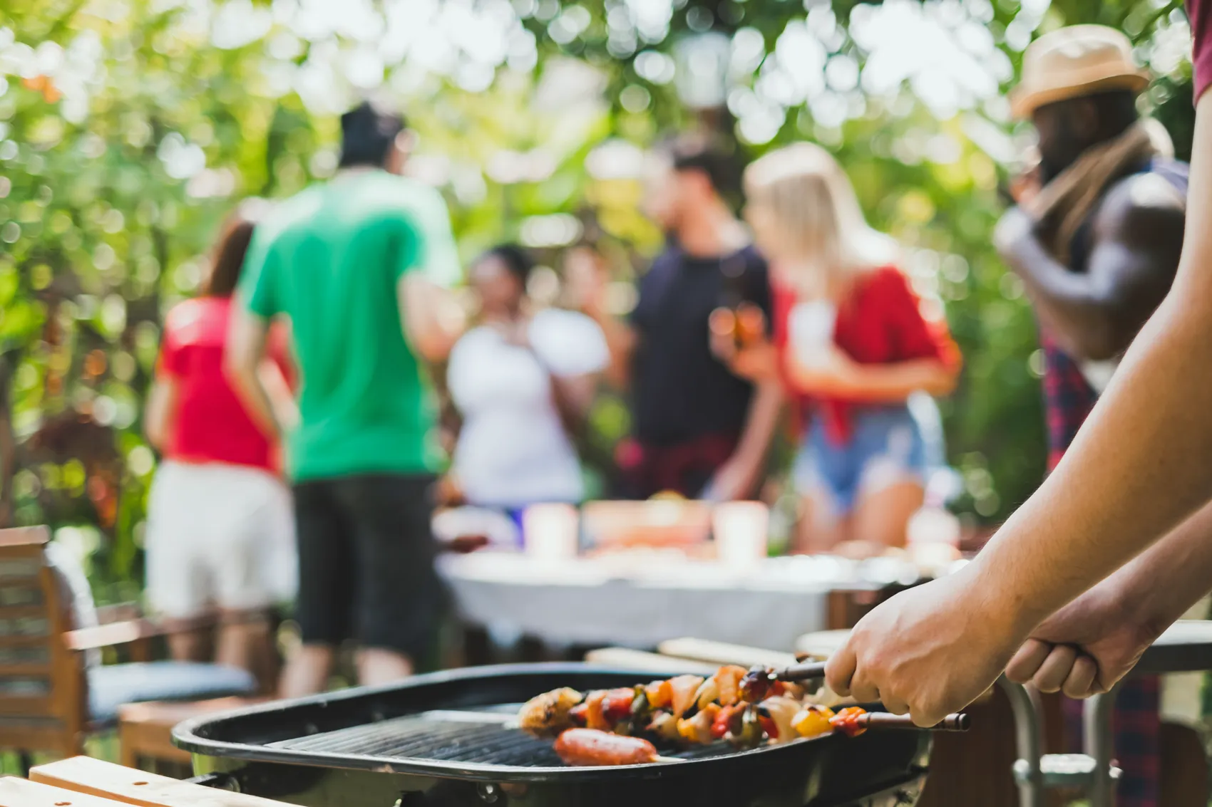 Friends gathered around an outdoor braai at a relaxed garden birthday lunch in South Africa
