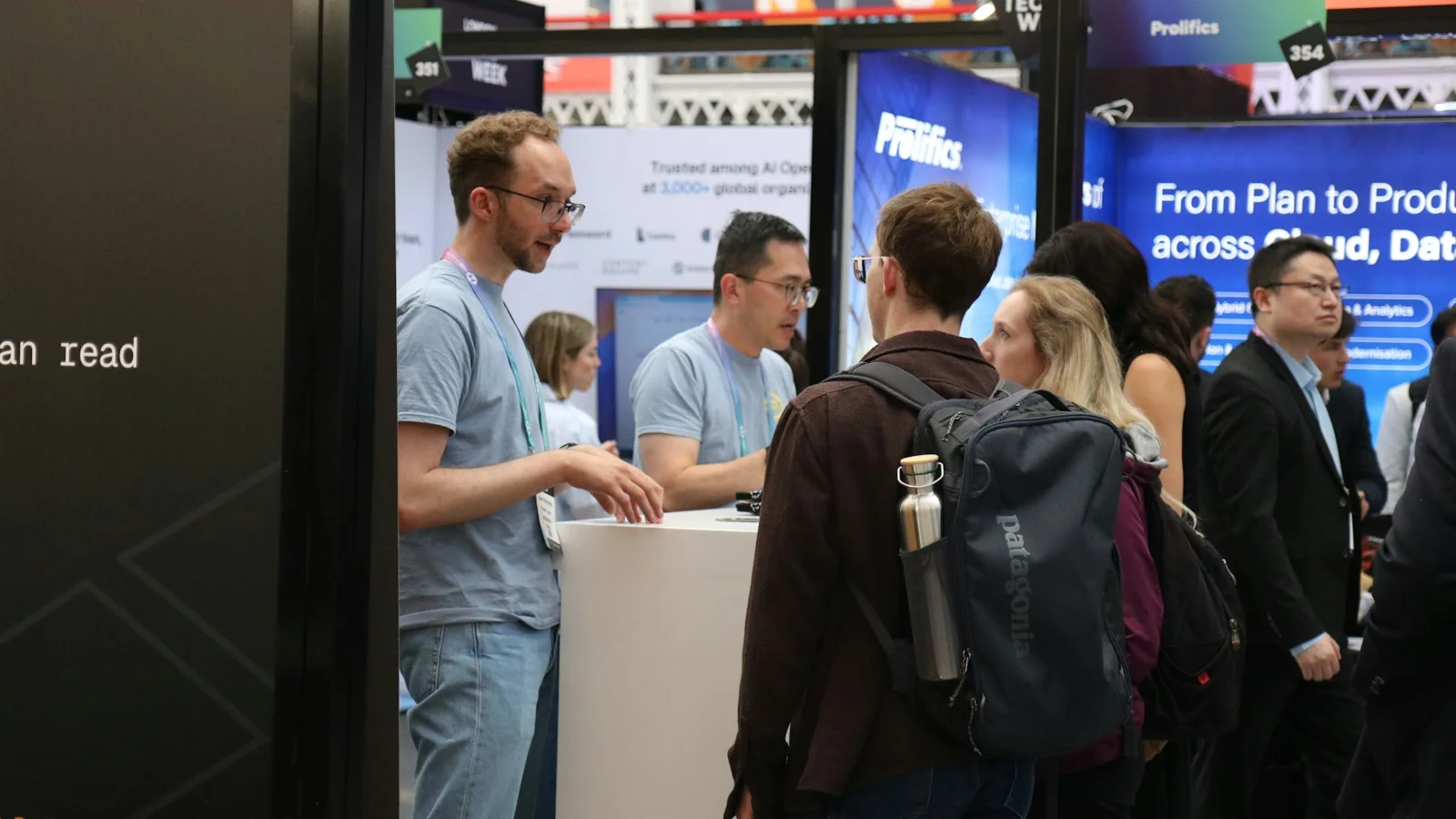 Exhibition stand staff talking with visitors at a busy trade show booth