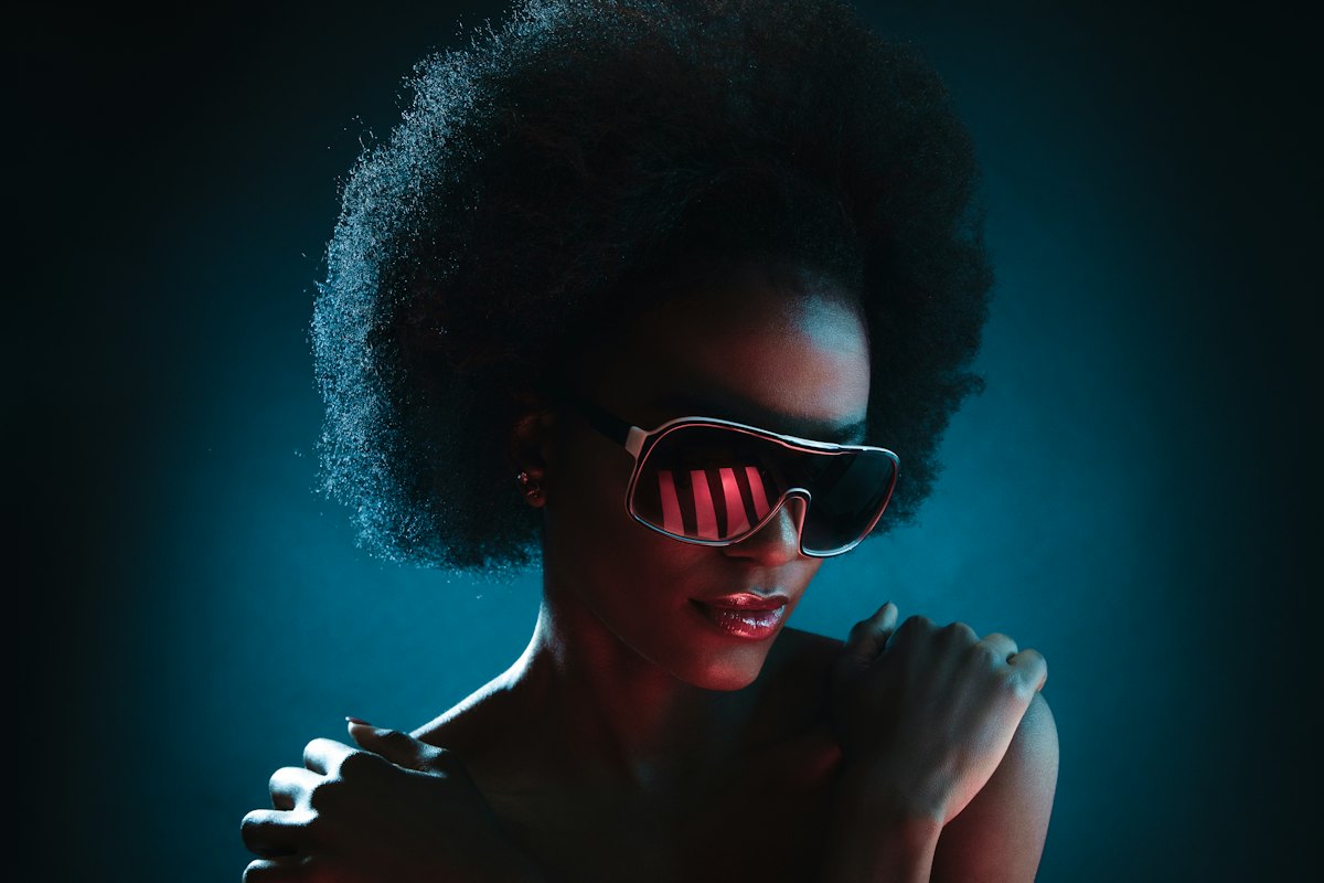 Afro-Futurist theme: a guest in glowing LED visor glasses under neon light