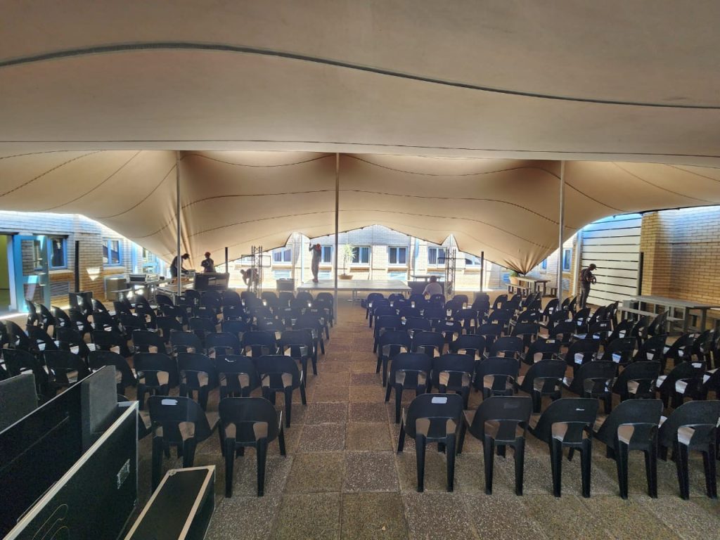 A spacious event venue featuring rows of rental chairs and tables.